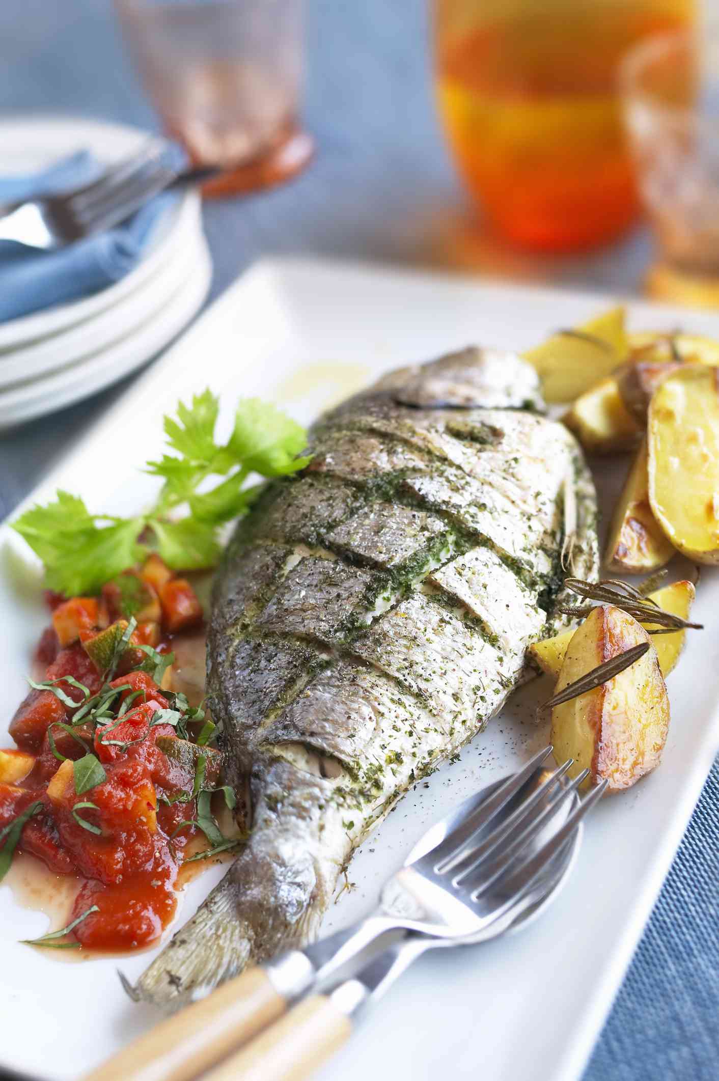 Gegrilde vis met kruiden, tomaat en geroosterde aardappelen