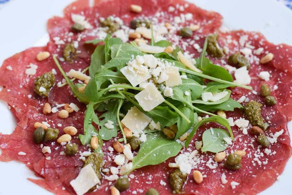 Carpaccio met rucola, Parmezaan en pijnboompitten